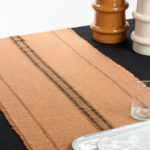 Chemin de table terracotta rayé noir avec finition frangée et délavage vintage