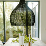 Suspension en rotin noire au design moderne et minimaliste.