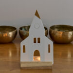 Bougeoir église en bois composé d’un support pour deux bougies chauffe-plat et d’une église en biscuit de porcelaine blanche. Il diffuse une lumière douce et donne une touche de poésie à votre intérieur.
