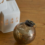 Boule vintage et bohème marron glacé et doré. Un vrai atout déco pour votre sapin de Noël et et vos décorations de fin d’année.
