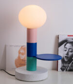 Magnifique lampe ” Agathe” de la marque Ciluzio d’AAMA Design. Elle est composée d’un socle subtilement moucheté et d’un empilement de 3 cylindres (dont un avec un petit plateau), le tout surplombé par un globe opaline translucide qui diffuse une lumière douce et subtile.