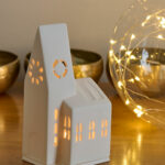 Photophore en porcelaine blanche représentant une église de village. Il diffuse une lumière douce et donne une touche de poésie à votre intérieur. Parfait pour votre décoration des fêtes de fin d’année.